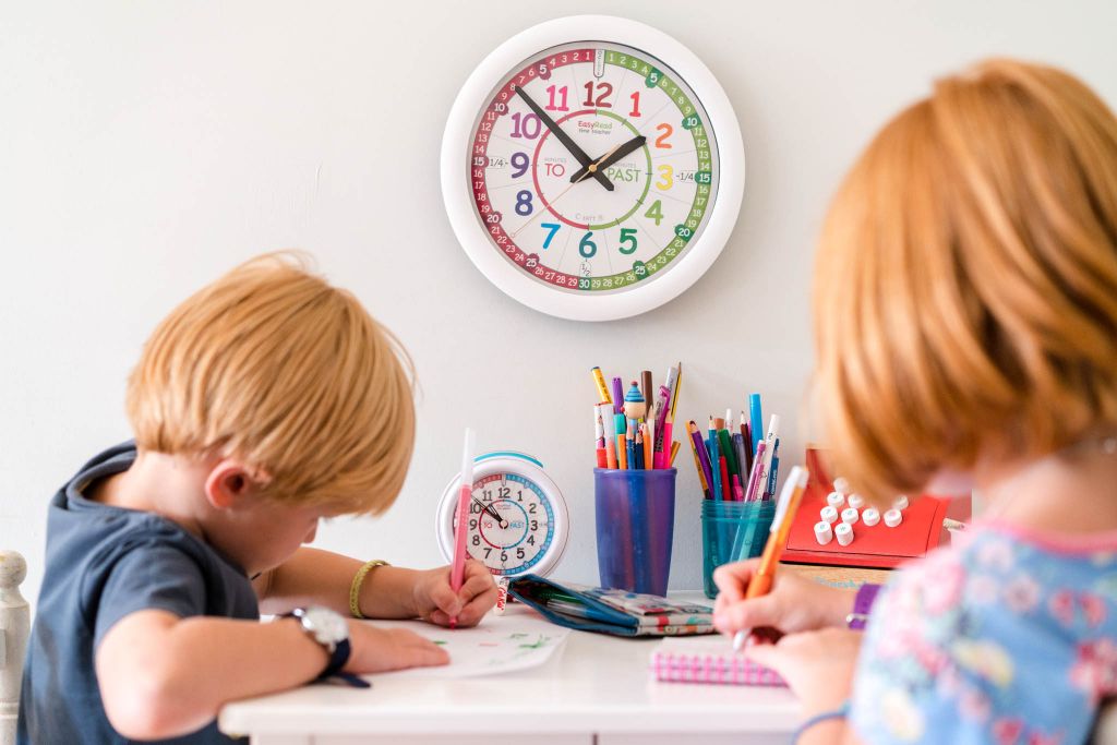 Two children learning how to tell the time with an EasyRead Time Teacher Wall Clock.
