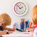 Two children learning how to tell the time with an EasyRead Time Teacher Wall Clock.